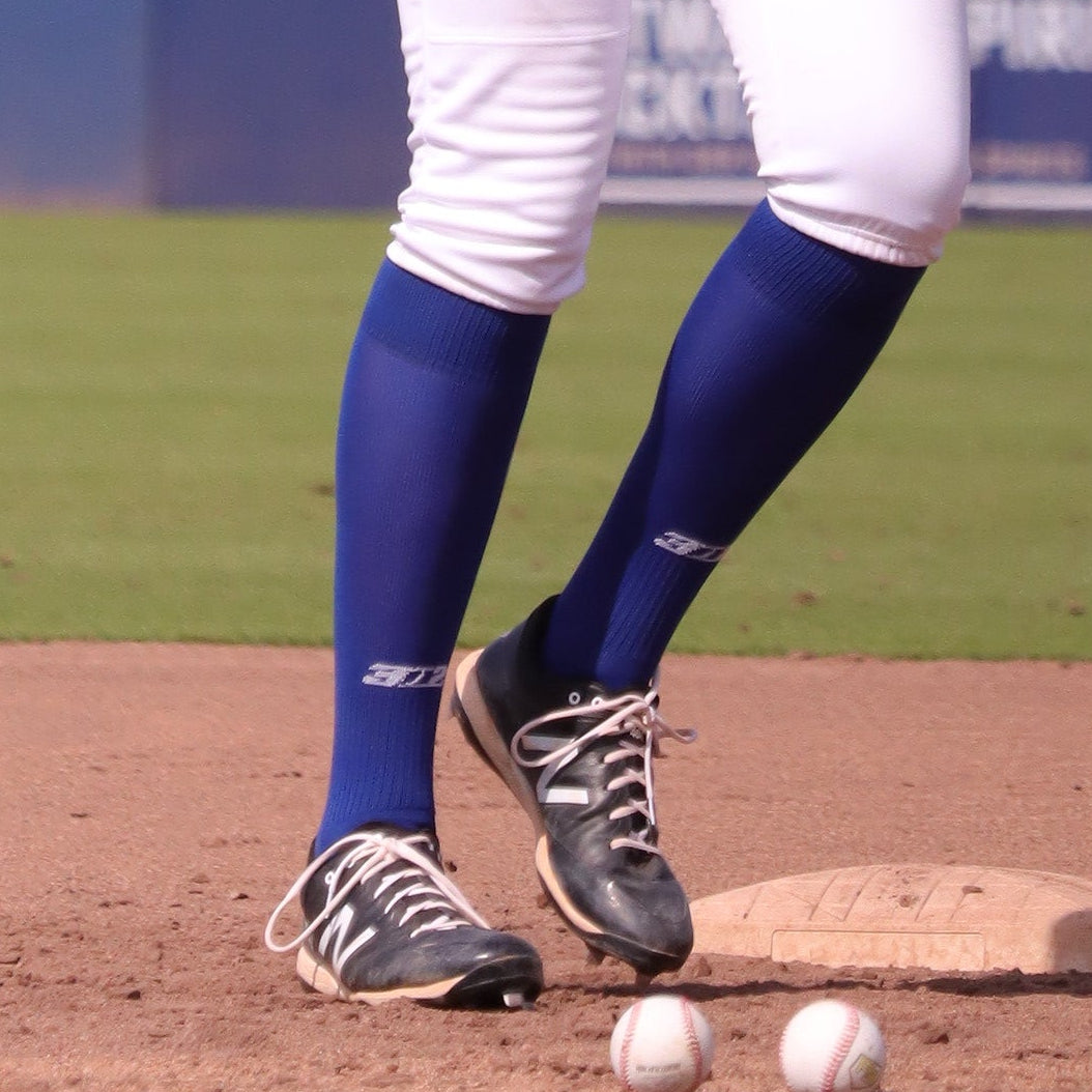 Baseball player in action on a field with advertisements in the background